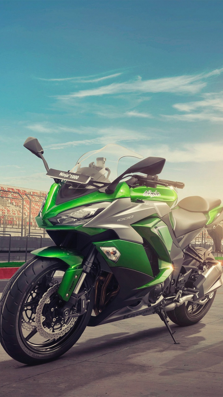 Man in Brown Jacket and Yellow Pants Riding on Black and White Sports Bike During Daytime. Wallpaper in 720x1280 Resolution