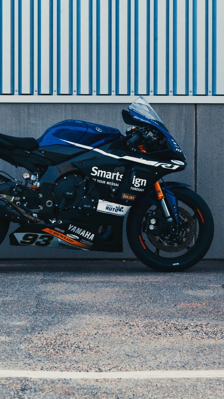 Schwarz-rotes Sportfahrrad Neben Grauem Rolltor Geparkt. Wallpaper in 720x1280 Resolution