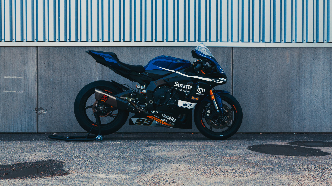 Black and Red Sports Bike Parked Beside Gray Roll up Door. Wallpaper in 1366x768 Resolution