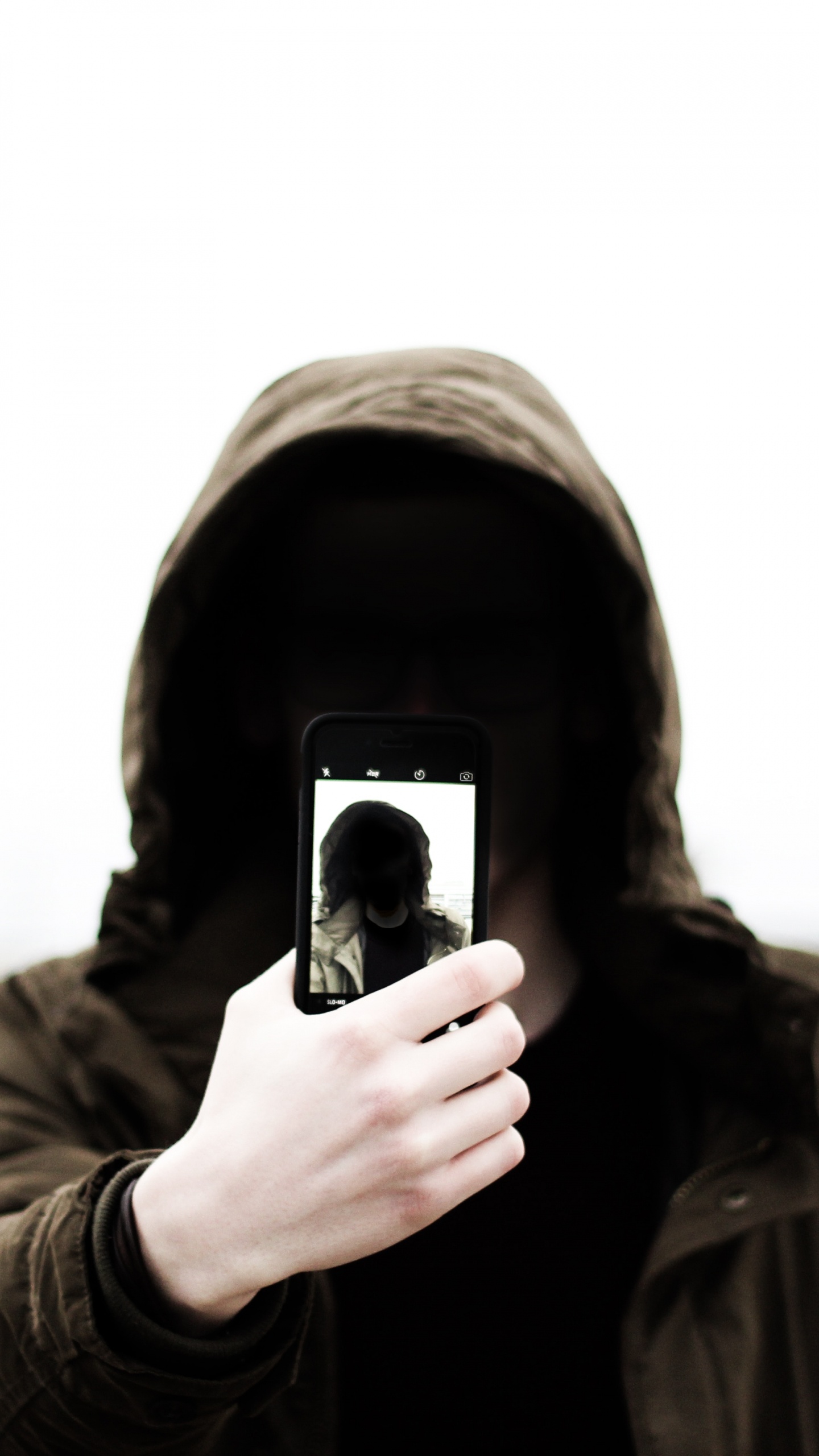 Grayscale Photo of Man in Hoodie Holding Phone. Wallpaper in 1440x2560 Resolution