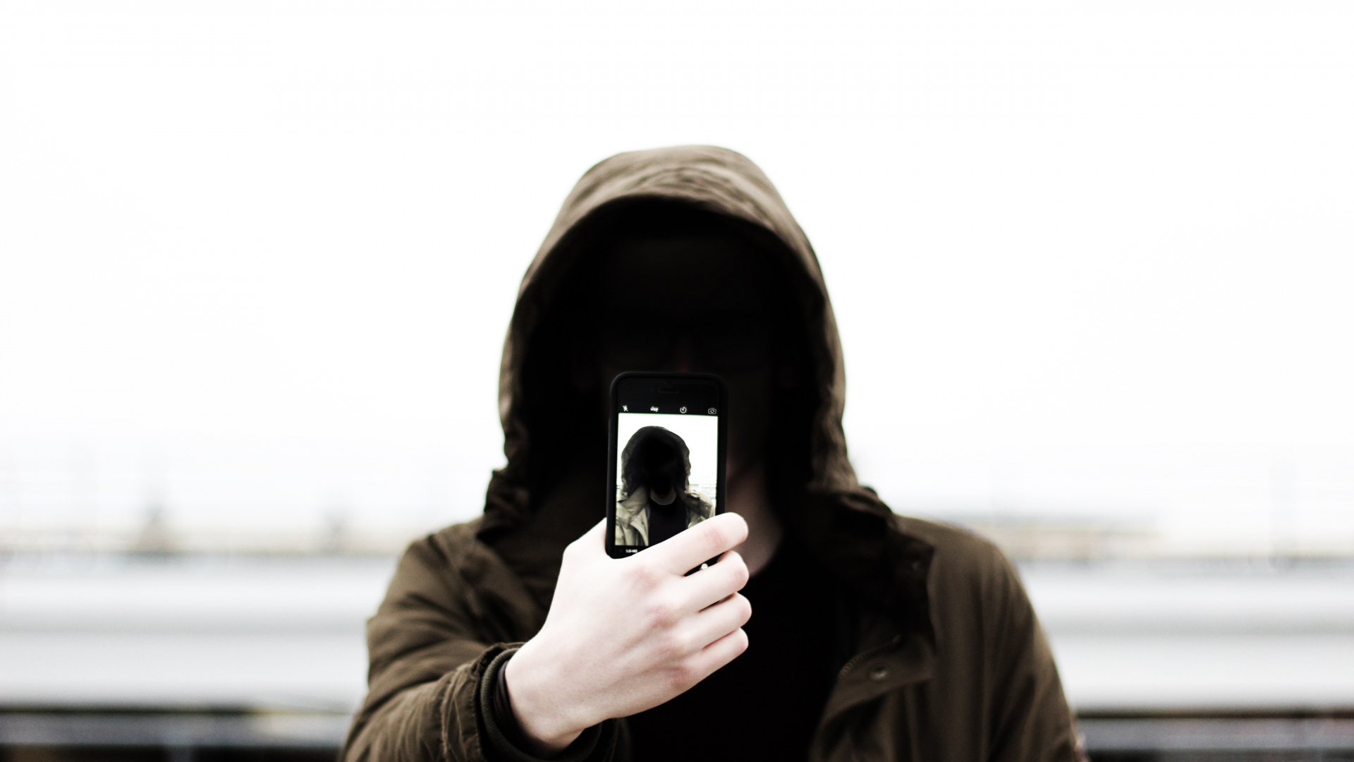 Grayscale Photo of Man in Hoodie Holding Phone. Wallpaper in 1920x1080 Resolution