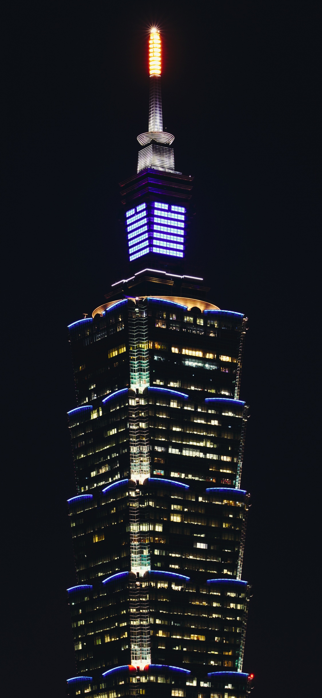 Schwarz-gelbes Hochhaus Während Der Nacht. Wallpaper in 1125x2436 Resolution