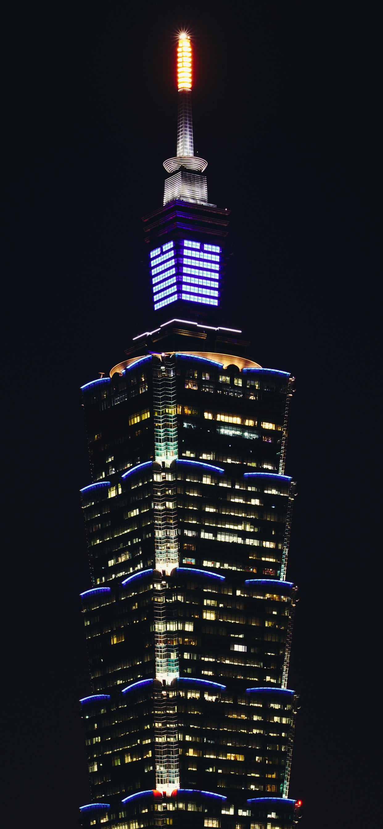 Schwarz-gelbes Hochhaus Während Der Nacht. Wallpaper in 1242x2688 Resolution