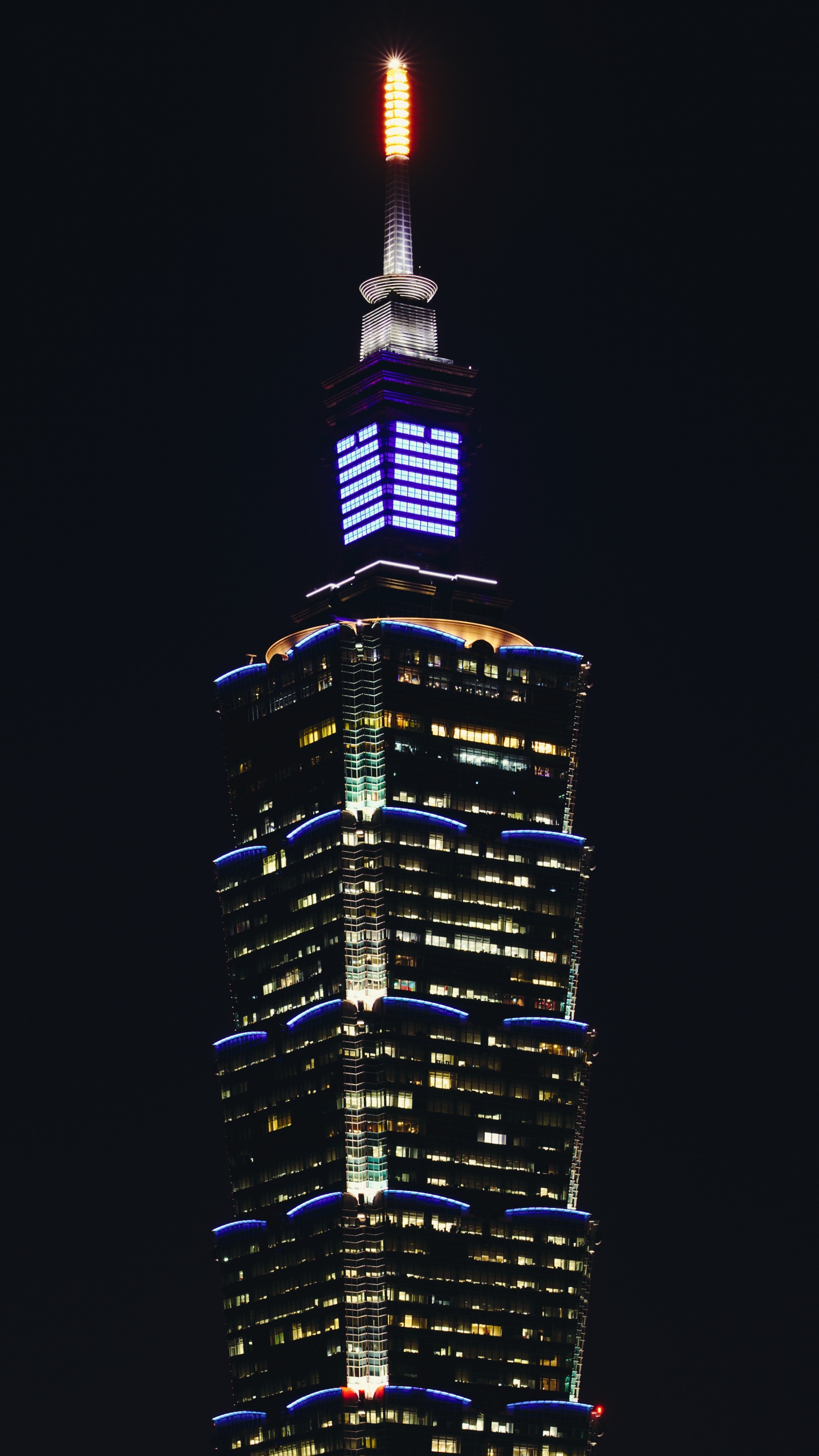 Schwarz-gelbes Hochhaus Während Der Nacht. Wallpaper in 1440x2560 Resolution