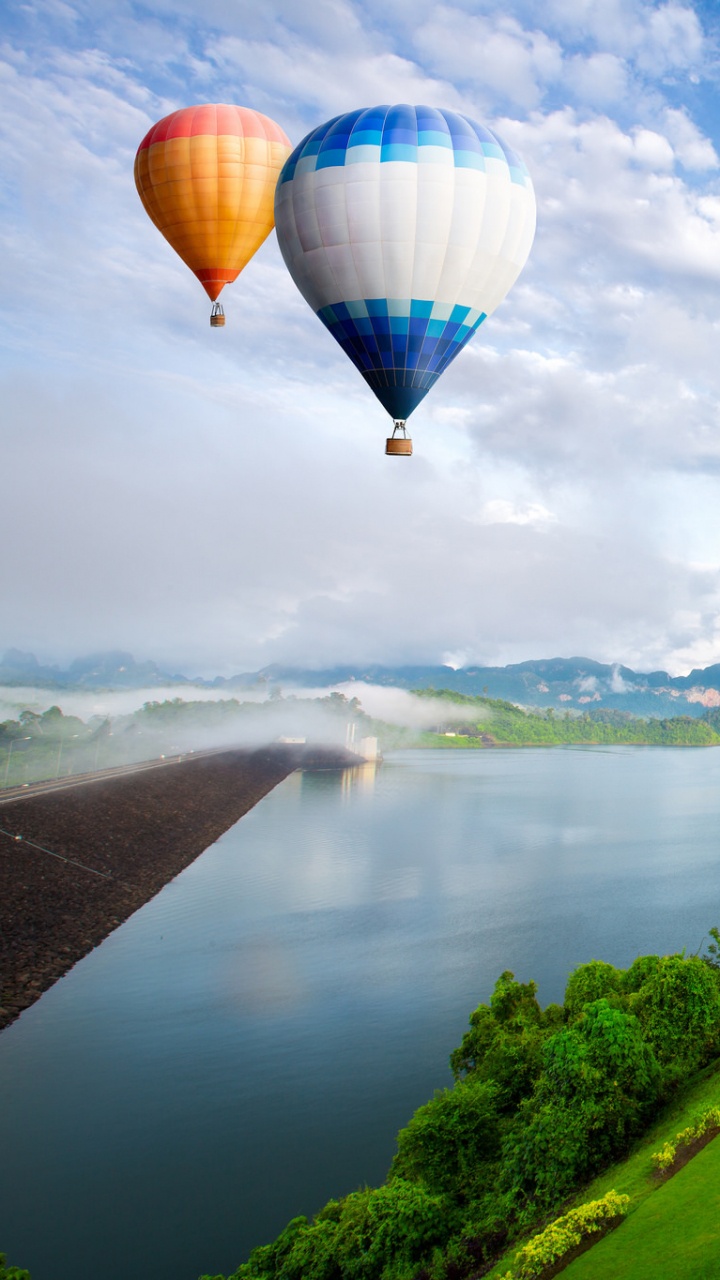 Hot Air Balloon Flying Over Green Grass Field Near Lake During Daytime. Wallpaper in 720x1280 Resolution