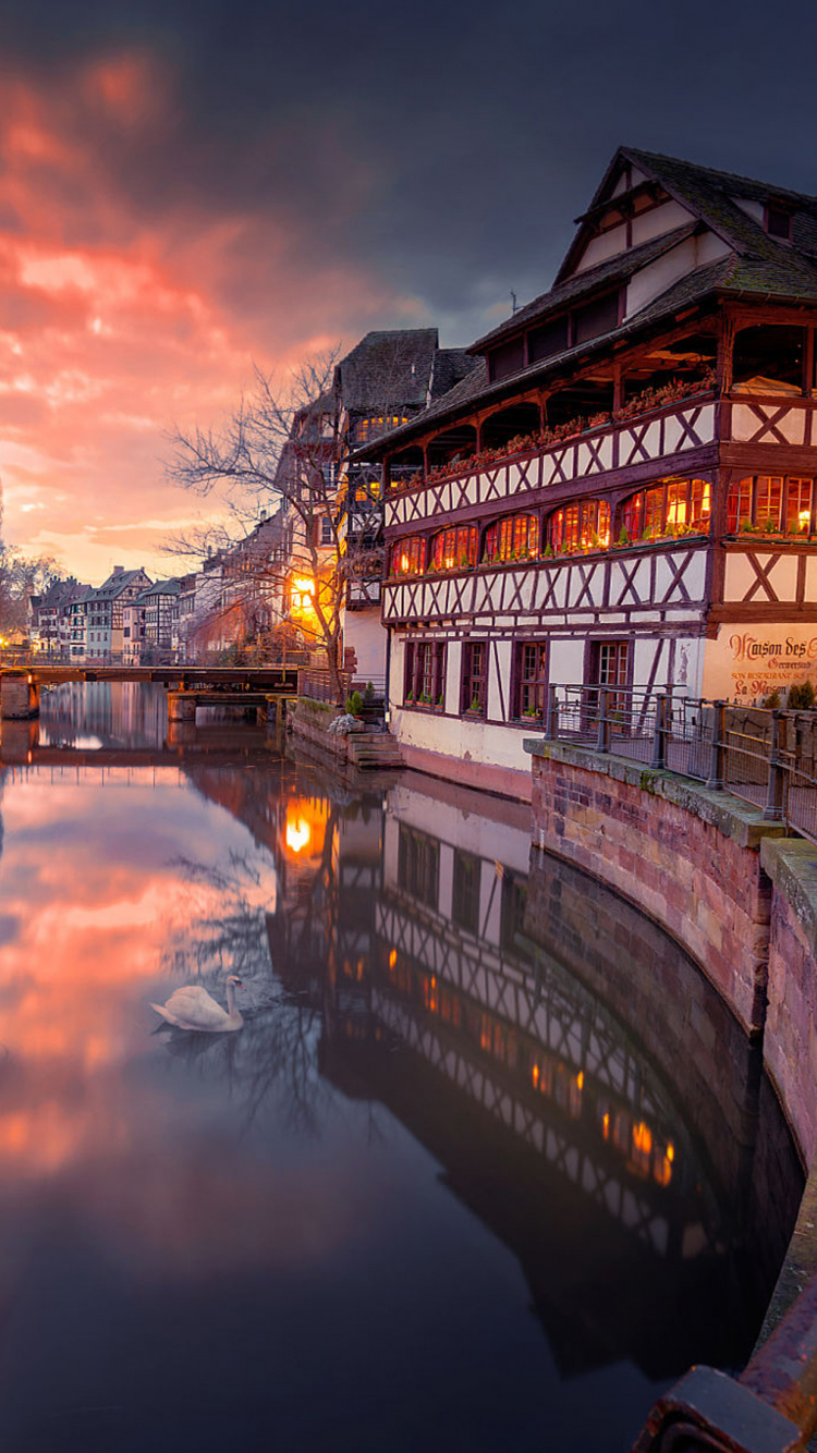 Bâtiment en Béton Brun et Blanc à Côté de la Rivière Pendant la Journée. Wallpaper in 750x1334 Resolution