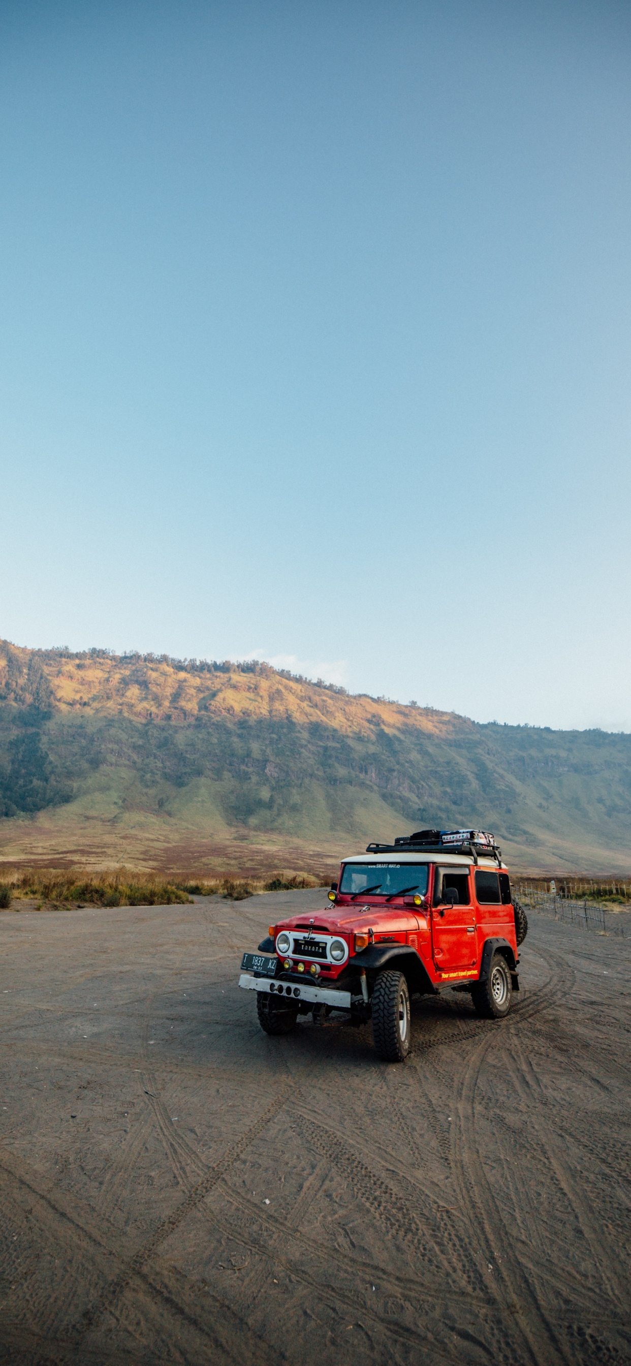 Suv Rouge Sur Champ Brun Pendant la Journée. Wallpaper in 1242x2688 Resolution