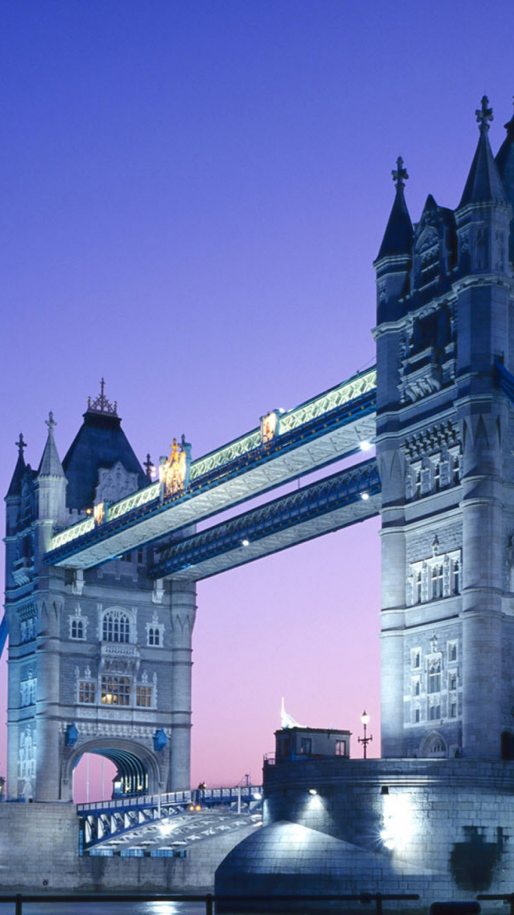 Homme en Veste Noire Sautant Sur le Pont Pendant la Nuit. Wallpaper in 750x1334 Resolution