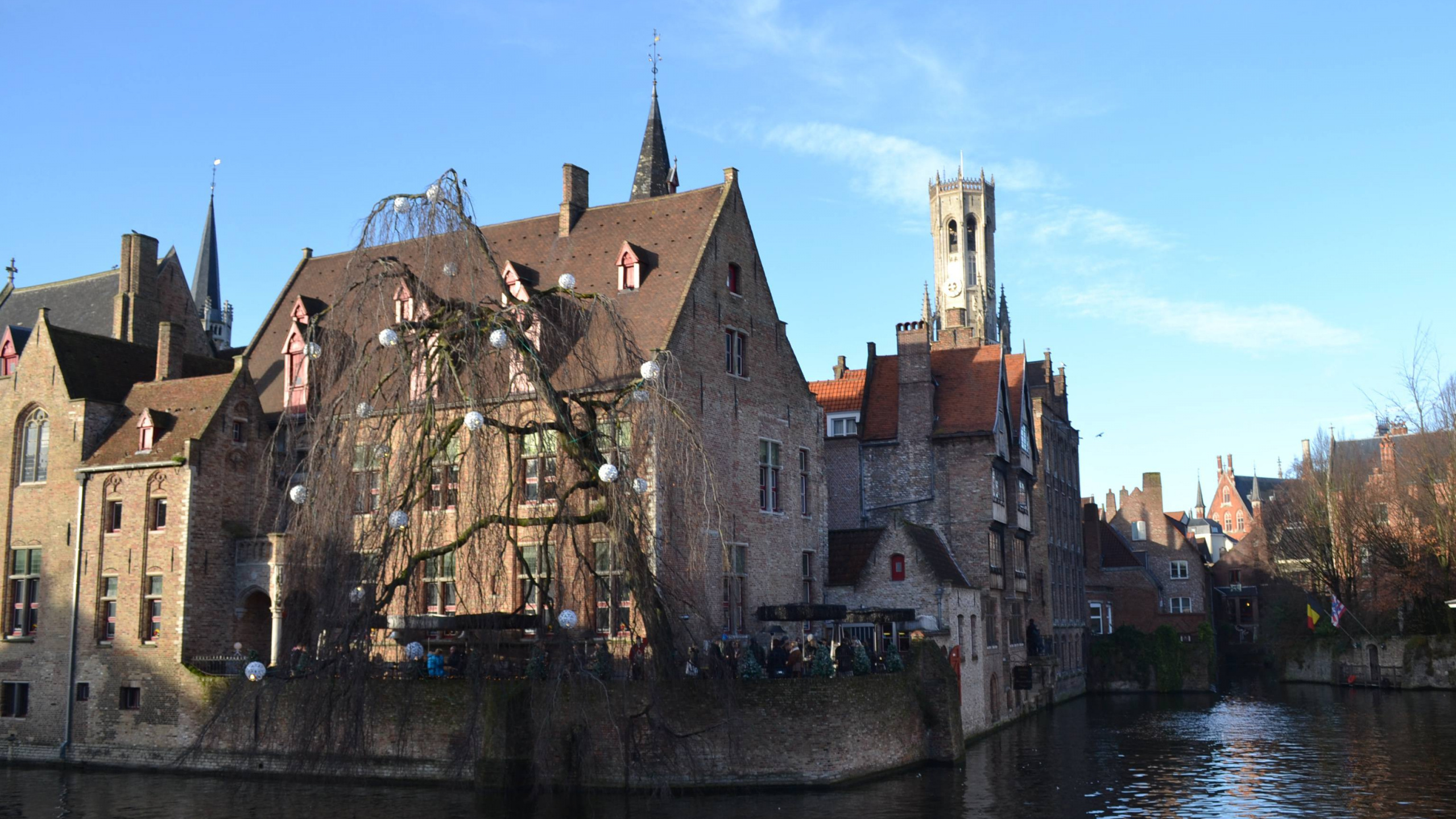 Brown Concrete Building Beside Body of Water During Daytime. Wallpaper in 2560x1440 Resolution