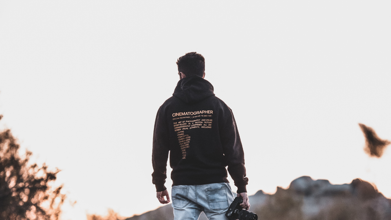 Man in Black Jacket and Blue Denim Jeans Walking on Rocky Road During Daytime. Wallpaper in 1280x720 Resolution