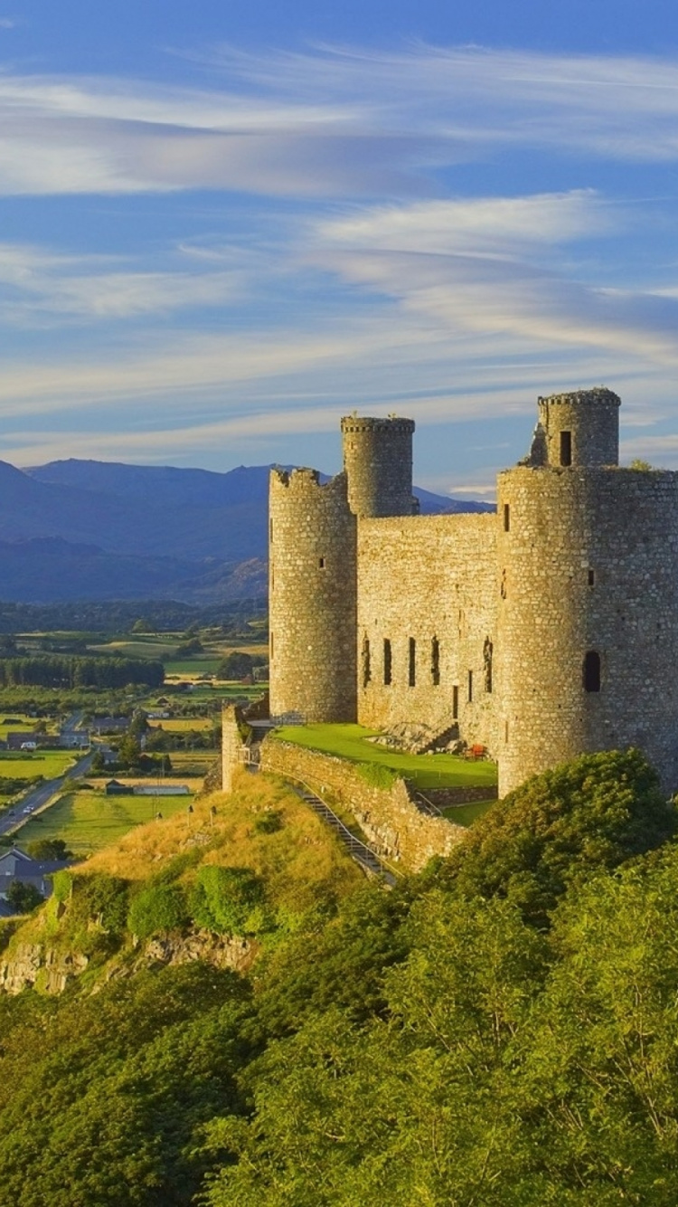 Castillo de Hormigón Gris en el Campo de Hierba Verde Bajo Las Nubes Blancas y el Cielo Azul Durante el Día. Wallpaper in 750x1334 Resolution