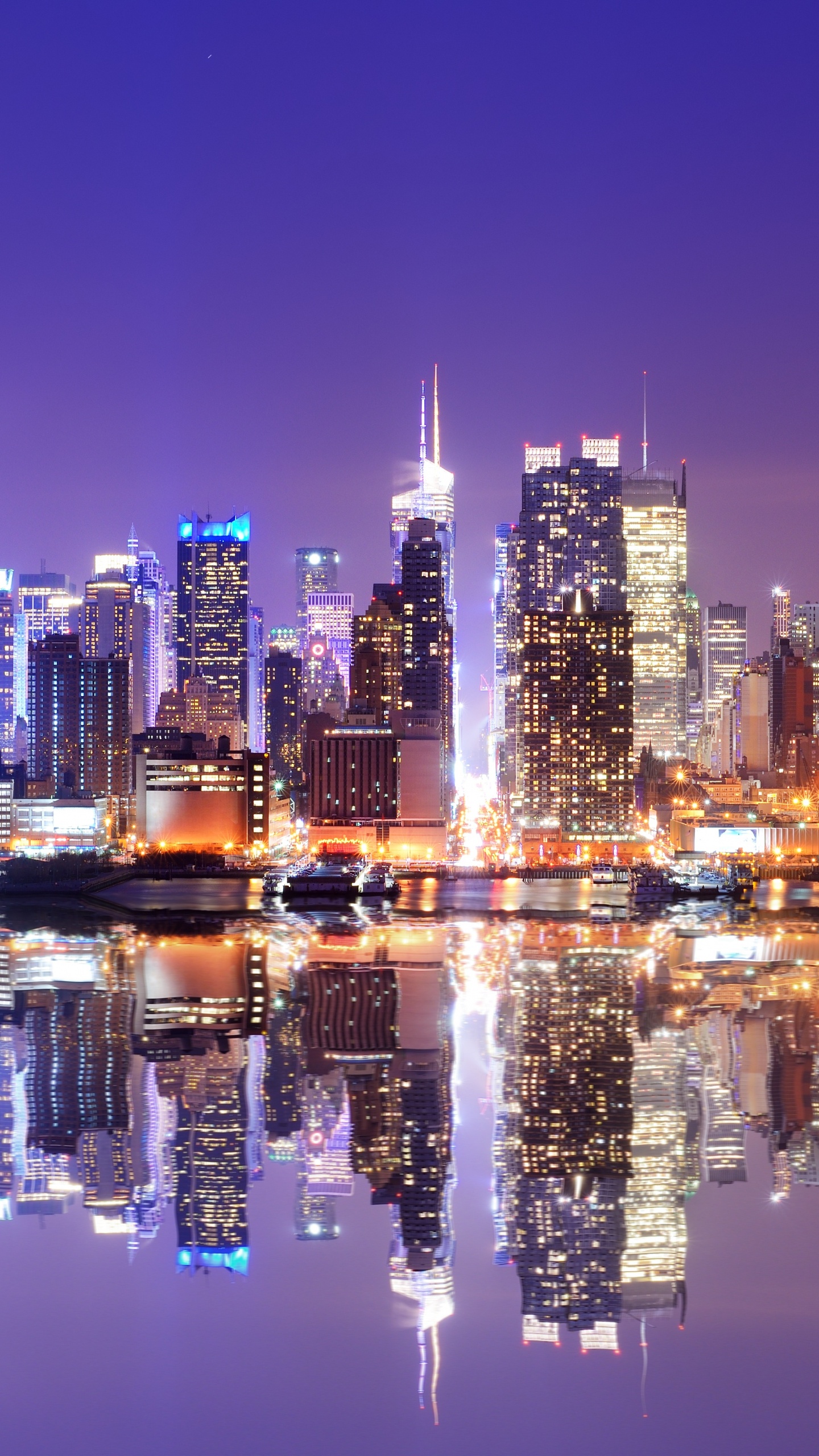 Skyline Der Stadt Über Gewässer Während Der Nacht. Wallpaper in 1440x2560 Resolution