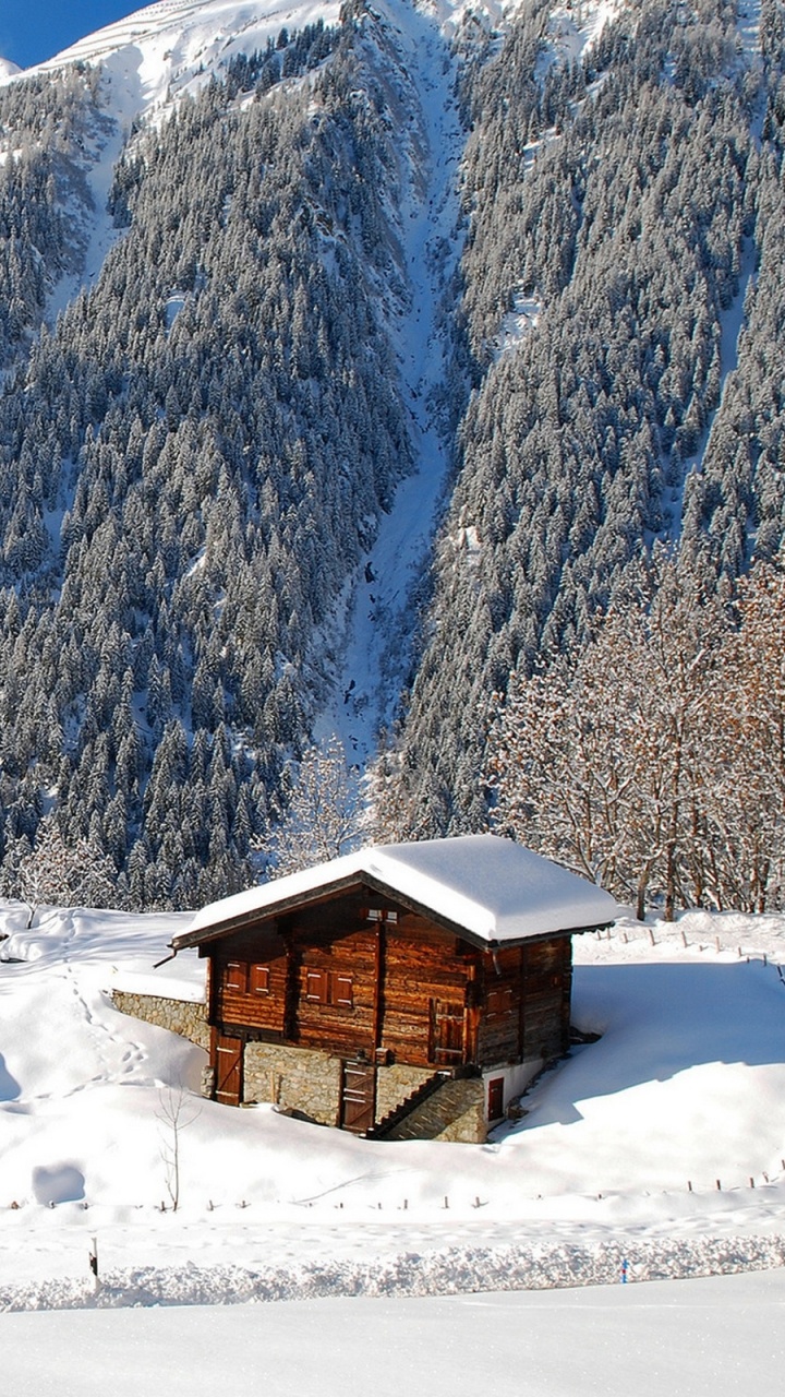 Braunes Holzhaus Auf Schneebedecktem Boden in Der Nähe Von Schneebedeckten Bergen Tagsüber During. Wallpaper in 720x1280 Resolution