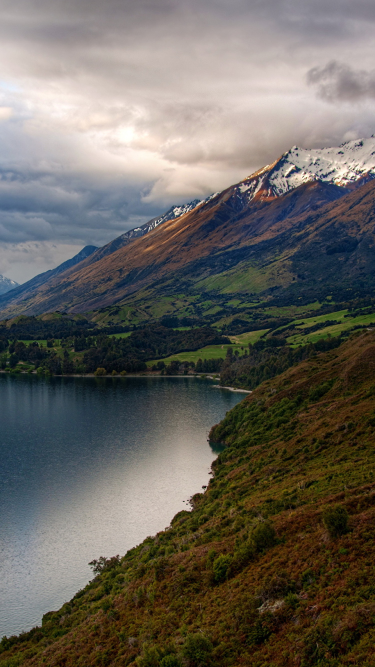 Lac au Milieu Des Montagnes Vertes et Brunes Sous Des Nuages Blancs. Wallpaper in 750x1334 Resolution