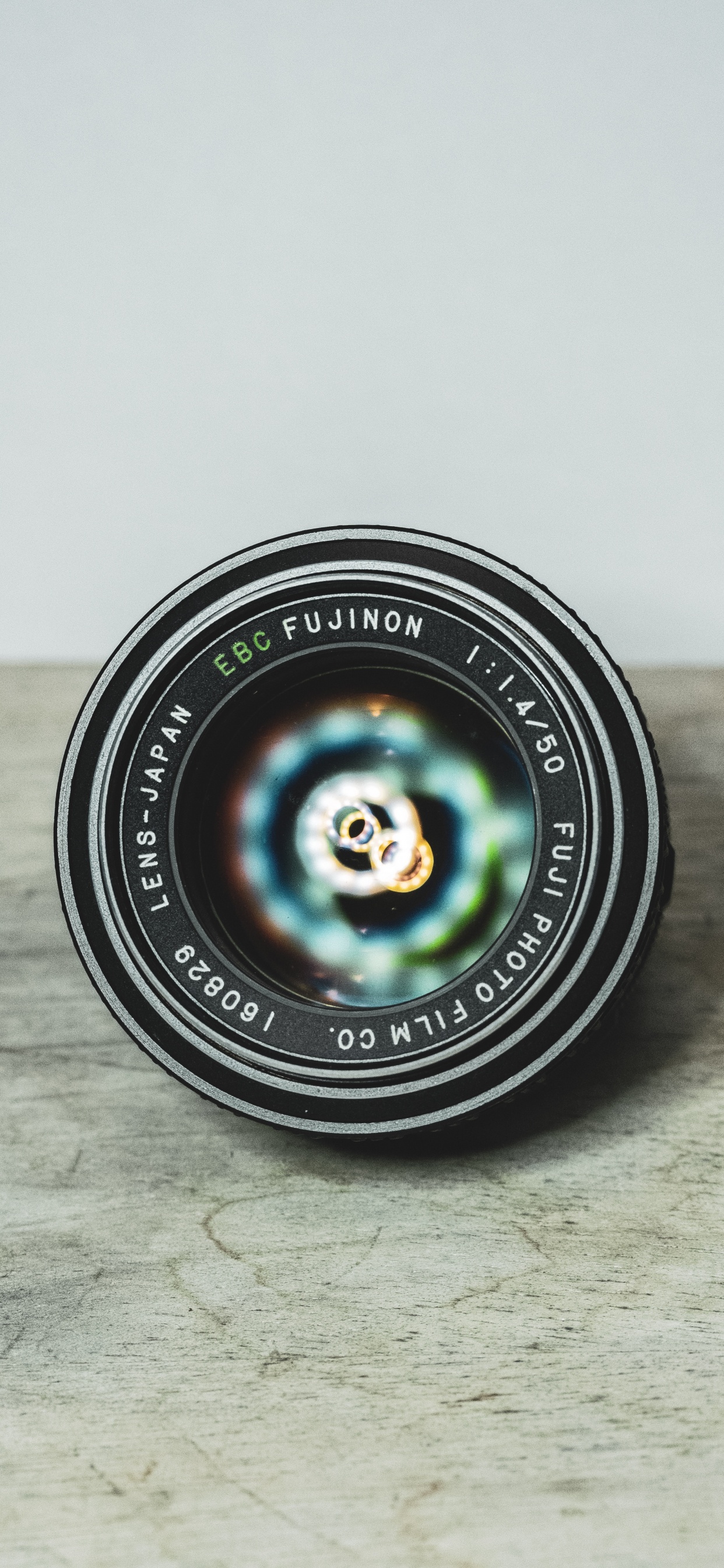 Objectif de Caméra Rond Noir Sur Une Table en Bois Marron. Wallpaper in 1242x2688 Resolution