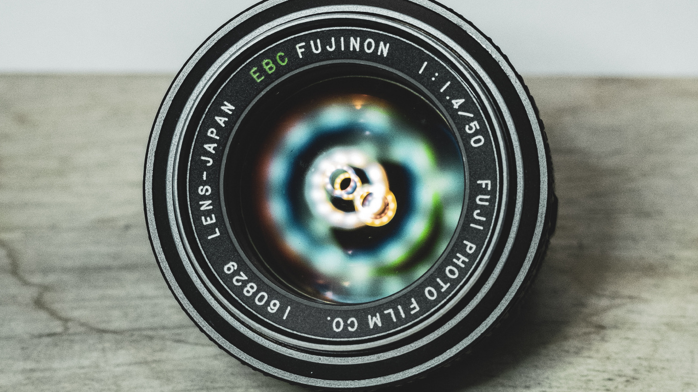 Objectif de Caméra Rond Noir Sur Une Table en Bois Marron. Wallpaper in 1366x768 Resolution