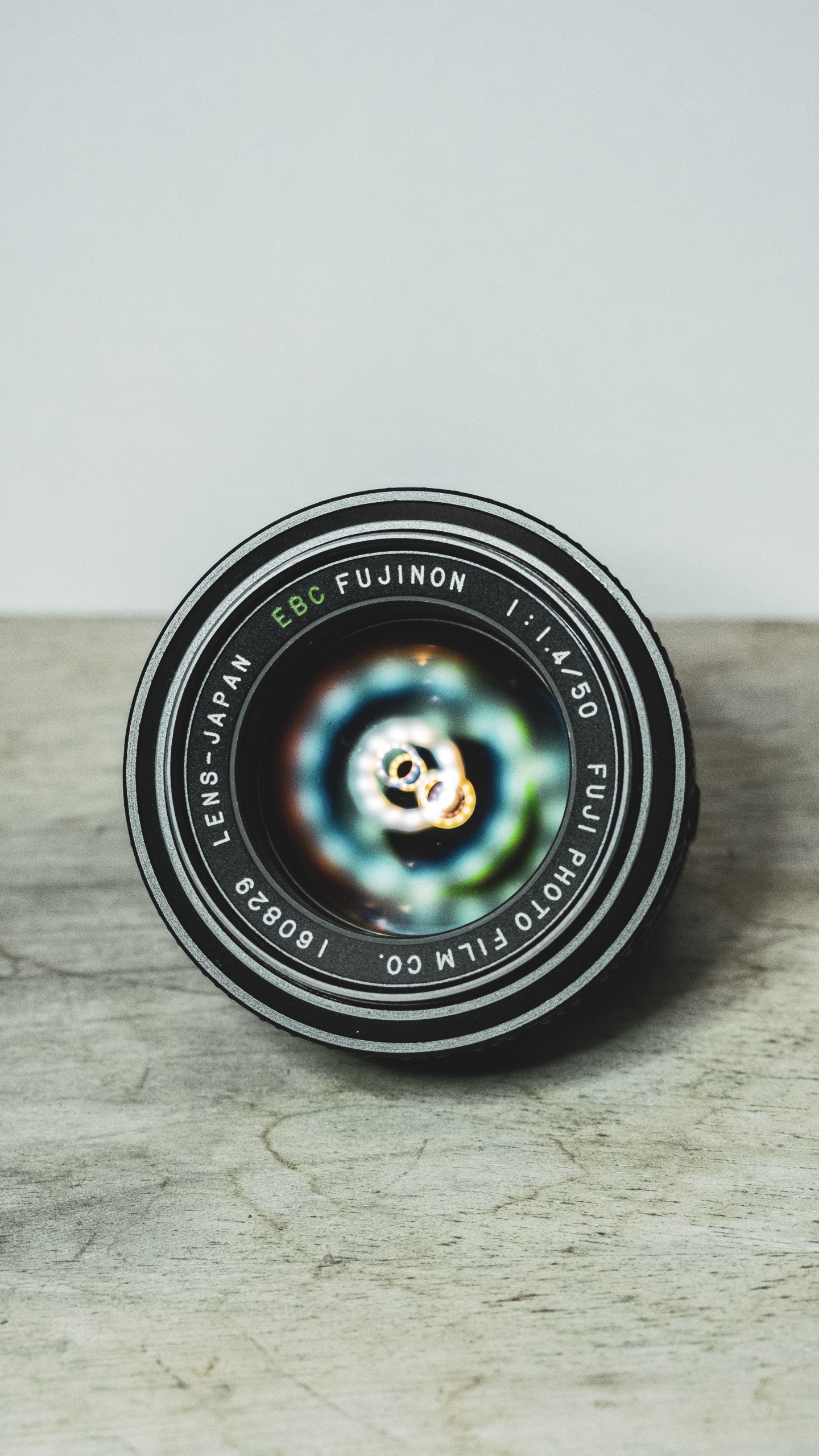 Black Round Camera Lens on Brown Wooden Table. Wallpaper in 1440x2560 Resolution