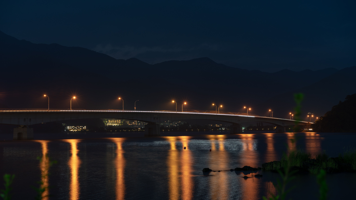 Beleuchtete Brücke Über Wasser Während Der Nacht Night. Wallpaper in 1366x768 Resolution