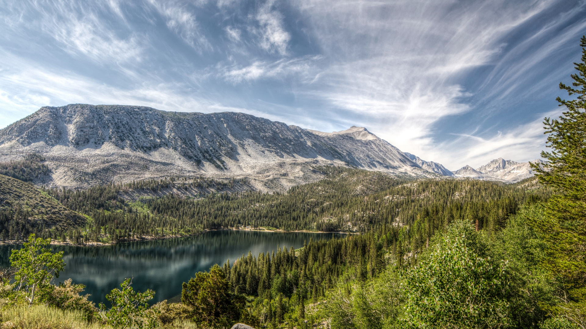 Grüne Wiese in Der Nähe Von See Und Berg Unter Blauem Himmel Tagsüber. Wallpaper in 1920x1080 Resolution