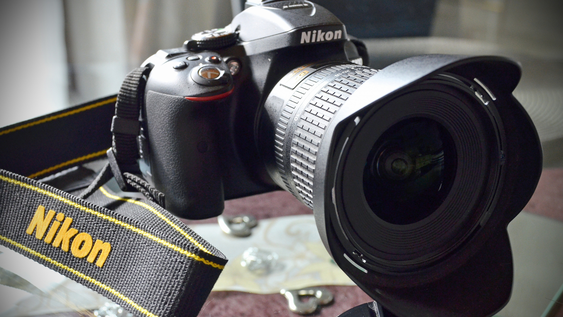 Schwarze Nikon Dslr Kamera Auf Braunem Und Schwarzem Textil. Wallpaper in 1920x1080 Resolution