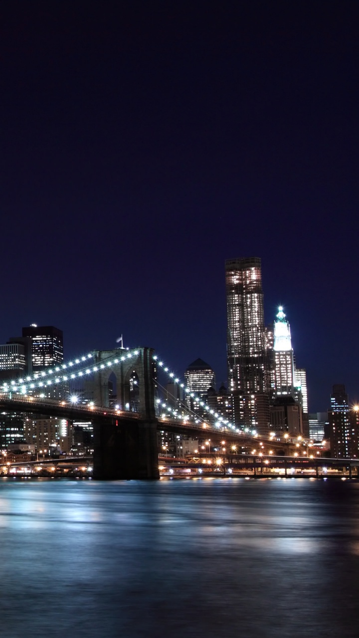 Lighted Bridge Over Water During Night Time. Wallpaper in 720x1280 Resolution