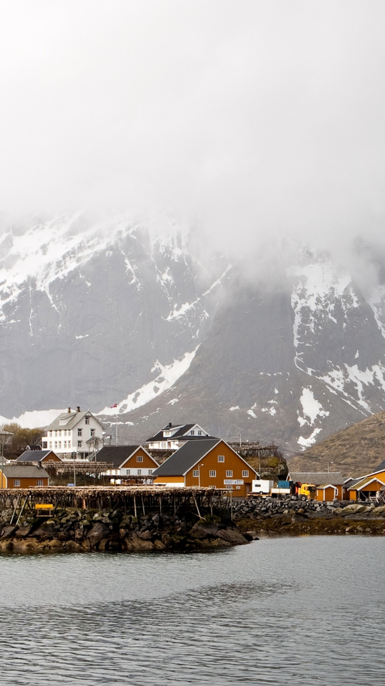 Brown Wooden Houses Near Snow Covered Mountain During Daytime. Wallpaper in 750x1334 Resolution