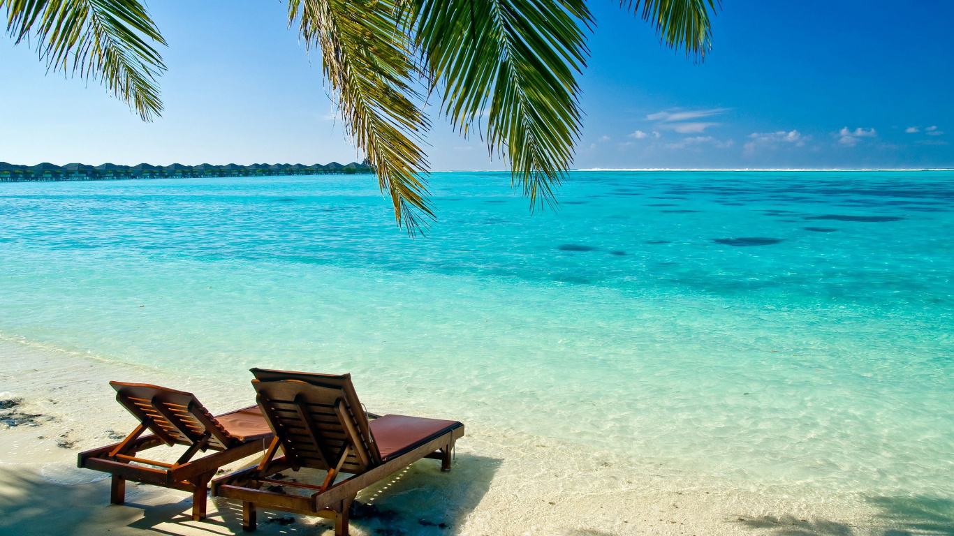 Brown Wooden Lounge Chairs on Beach During Daytime. Wallpaper in 1366x768 Resolution