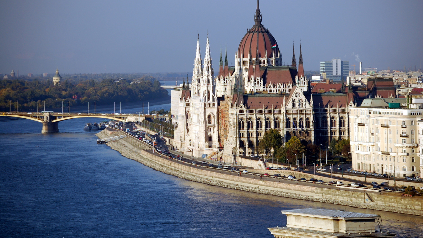 Weißes Und Braunes Betongebäude in Der Nähe Eines Gewässers Tagsüber. Wallpaper in 1366x768 Resolution