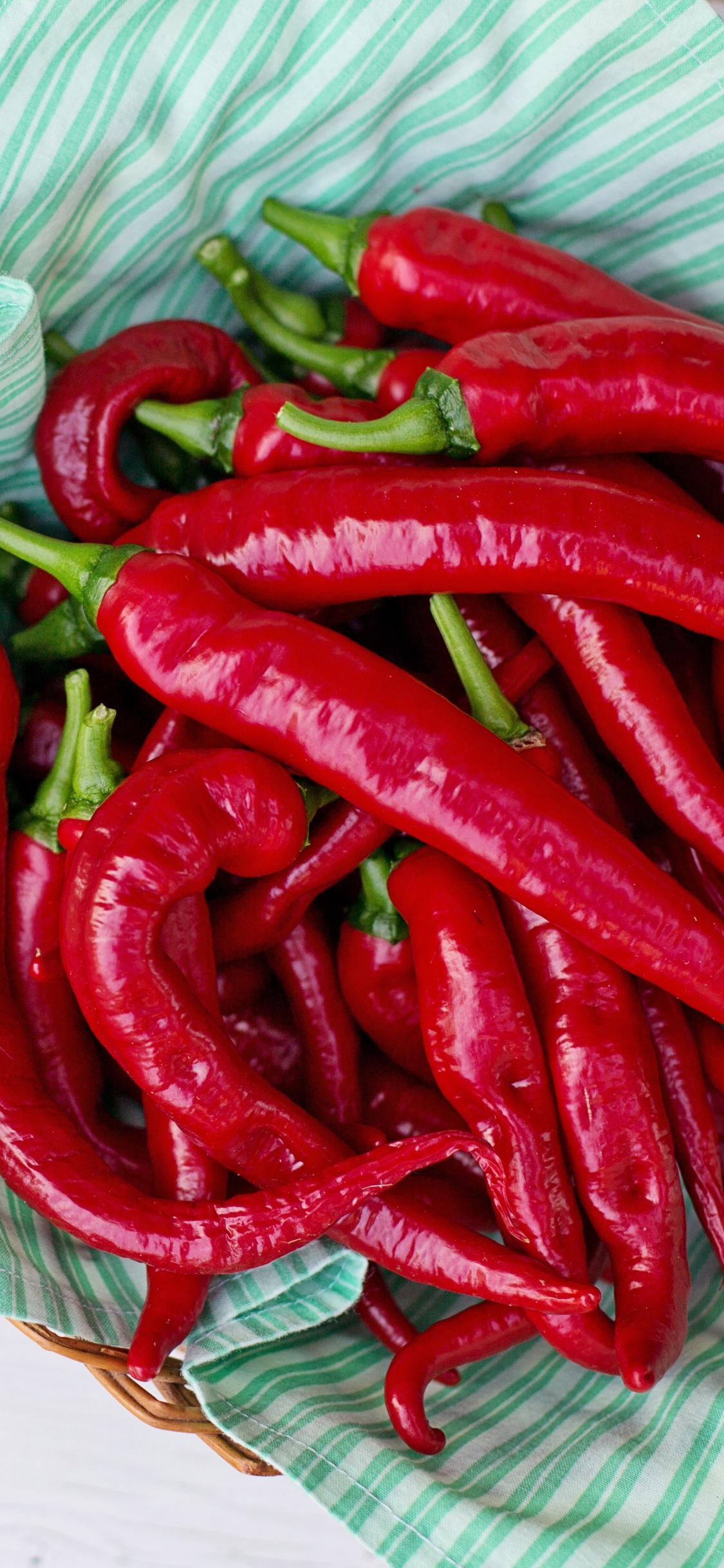 Chile Rojo Sobre Textil Blanco y Verde.. Wallpaper in 1125x2436 Resolution