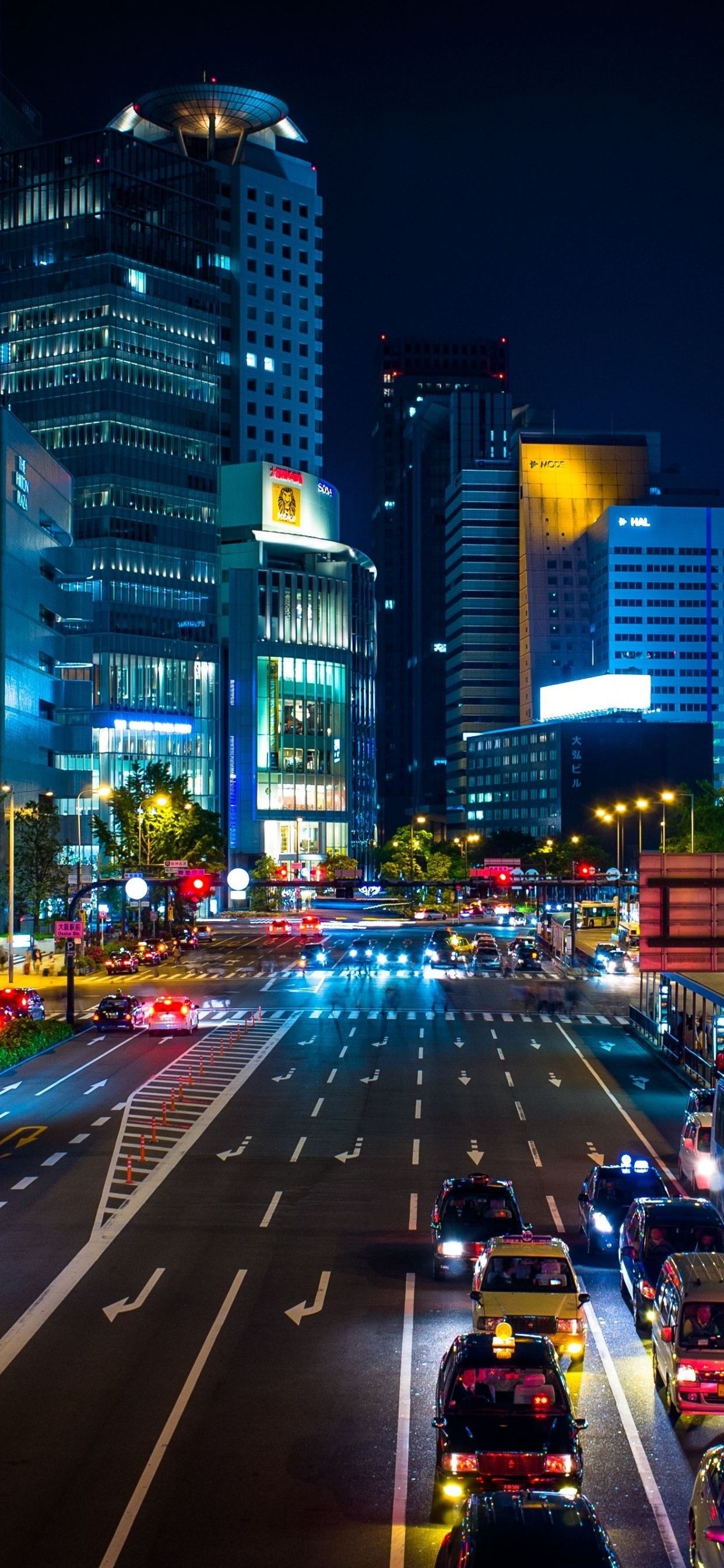 Cars on Road Between High Rise Buildings During Night Time. Wallpaper in 1242x2688 Resolution