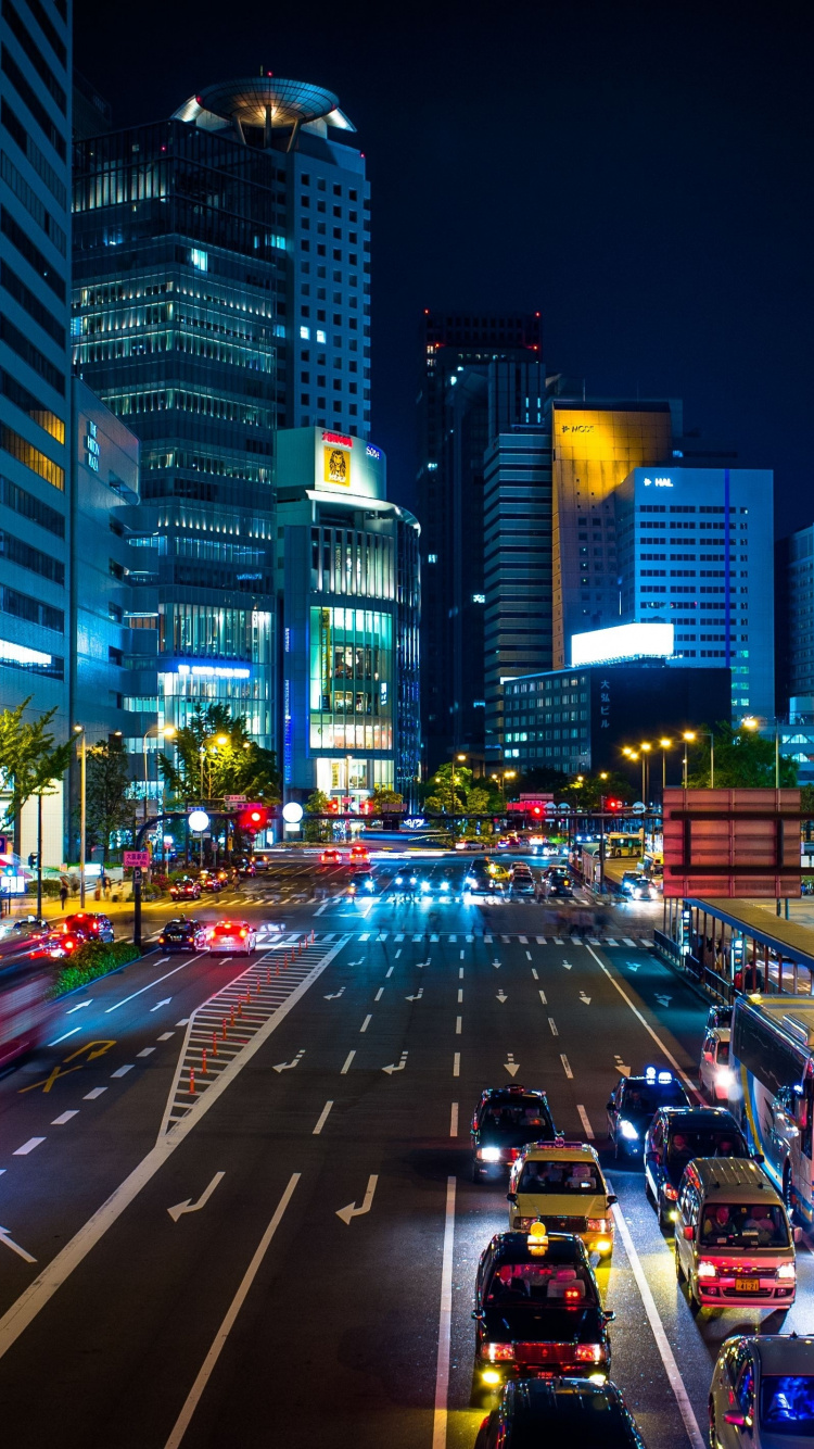 Cars on Road Between High Rise Buildings During Night Time. Wallpaper in 750x1334 Resolution