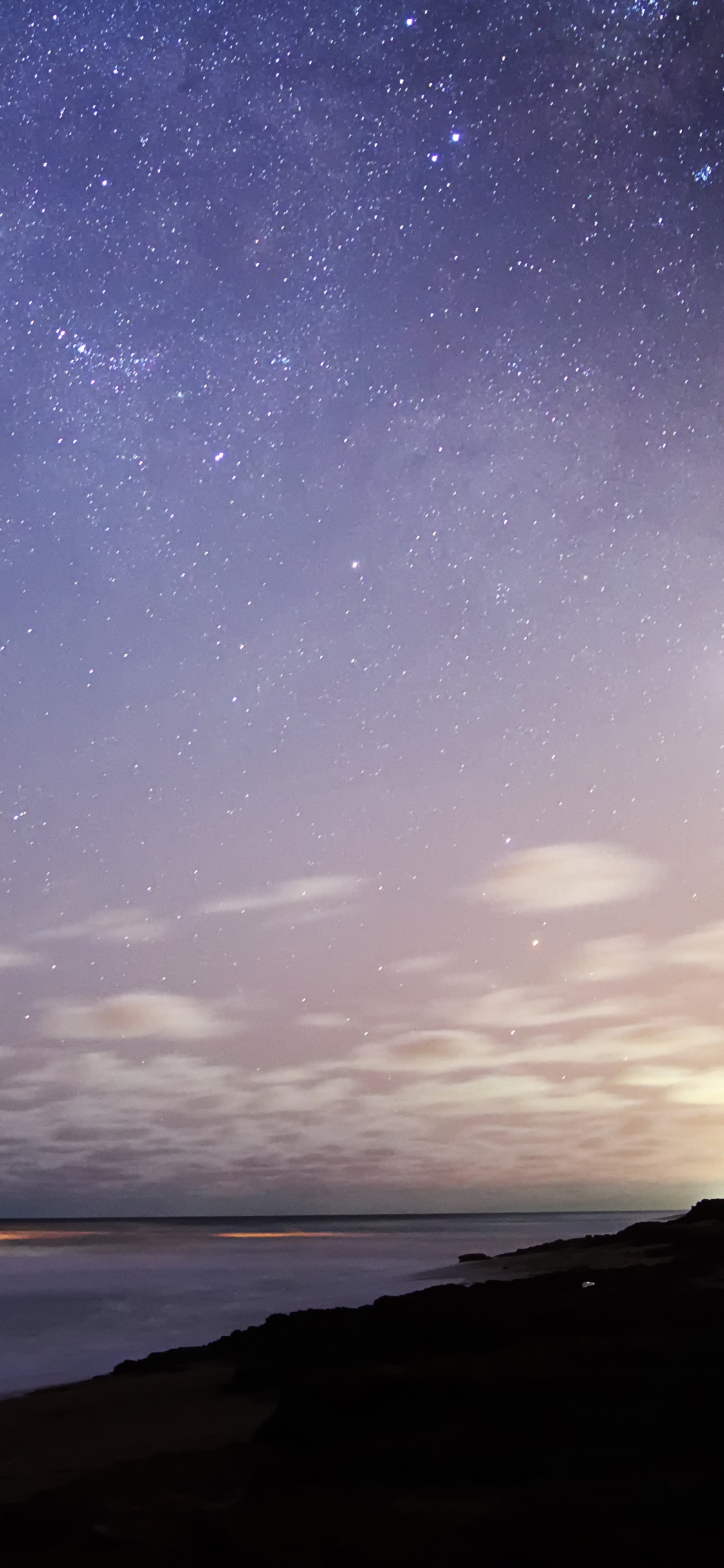 Body of Water Under Starry Night. Wallpaper in 1125x2436 Resolution