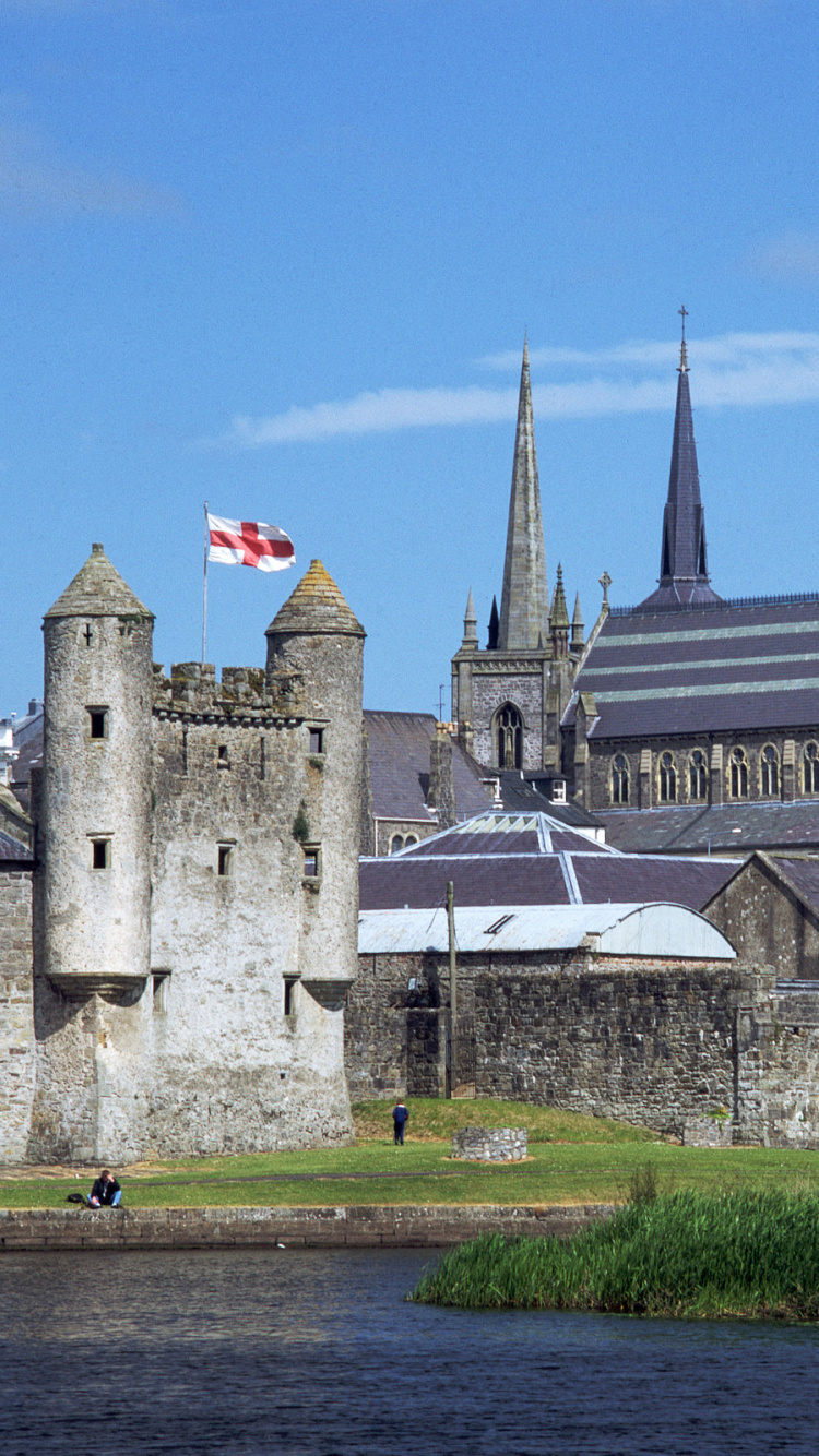 Edificio de Hormigón Gris Cerca Del Río Bajo un Cielo Azul Durante el Día. Wallpaper in 750x1334 Resolution