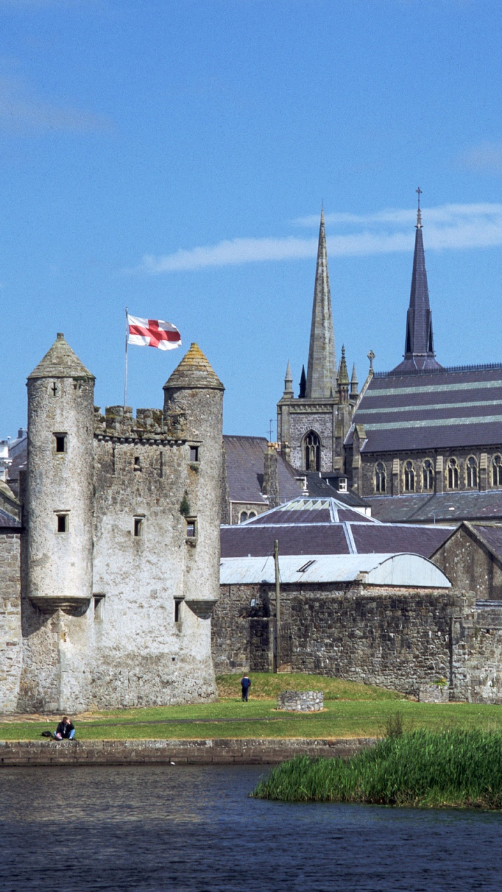 Graues Betongebäude in Der Nähe Des Flusses Unter Blauem Himmel Tagsüber. Wallpaper in 720x1280 Resolution