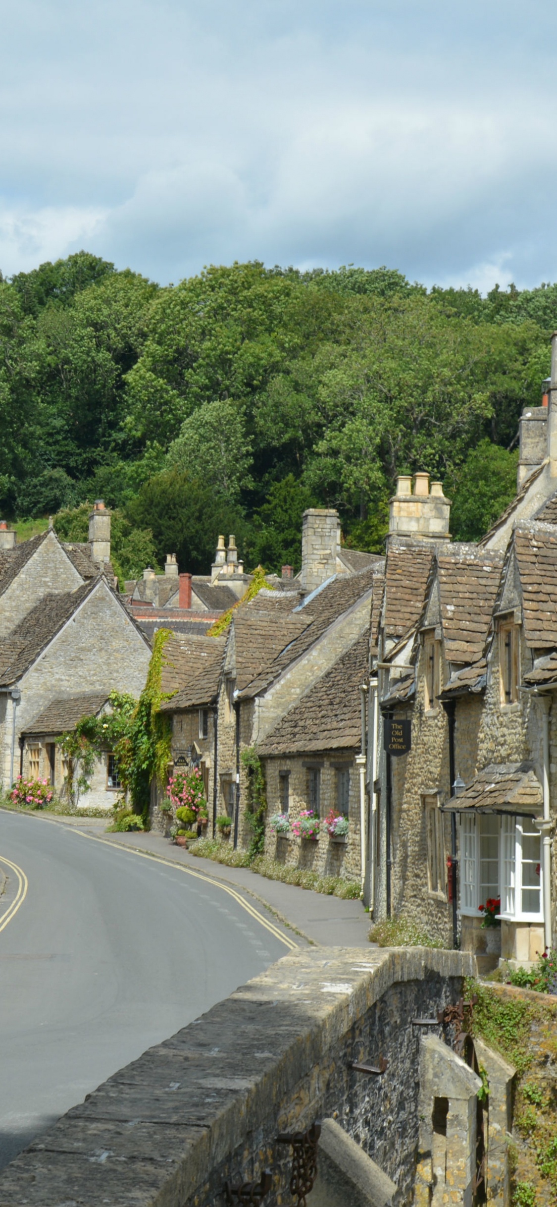 Route en Béton Gris Entre Les Arbres Verts et Les Maisons en Béton Marron Pendant la Journée. Wallpaper in 1125x2436 Resolution