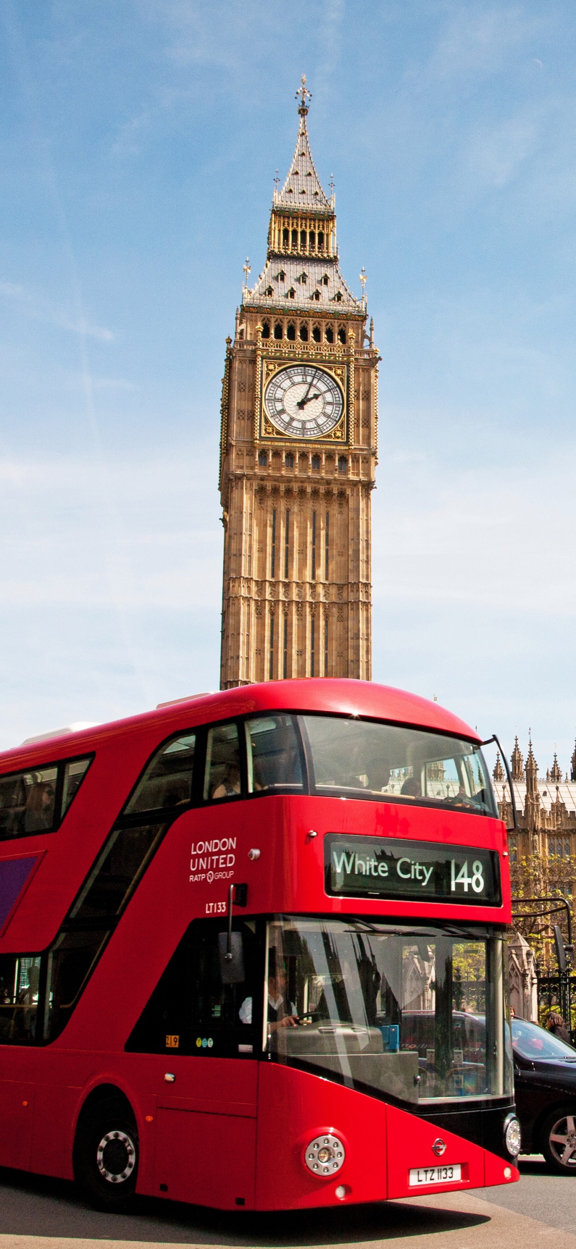 Red Double Decker Bus on Road Near Big Ben During Daytime. Wallpaper in 1125x2436 Resolution