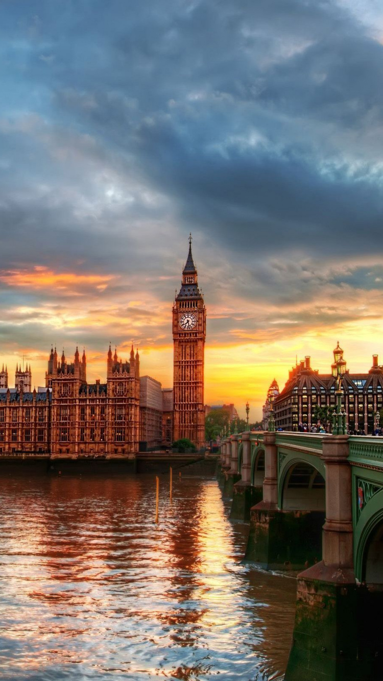 Brown Concrete Building Near Body of Water During Daytime. Wallpaper in 750x1334 Resolution