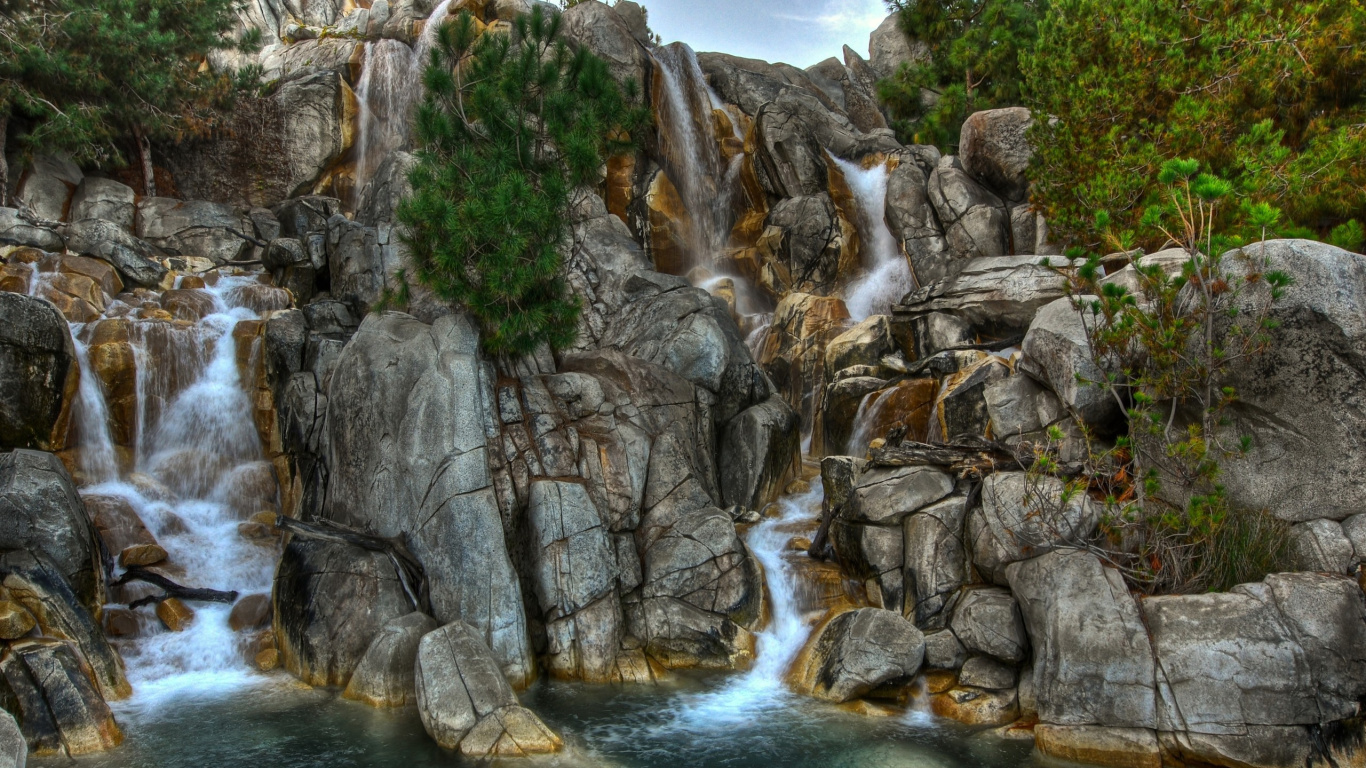 El Agua Cae Entre la Montaña Rocosa Gris Durante el Día.. Wallpaper in 1366x768 Resolution