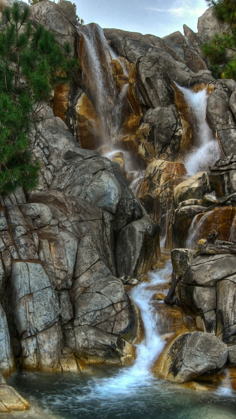 Water Falls Between Gray Rocky Mountain During Daytime. Wallpaper in 750x1334 Resolution