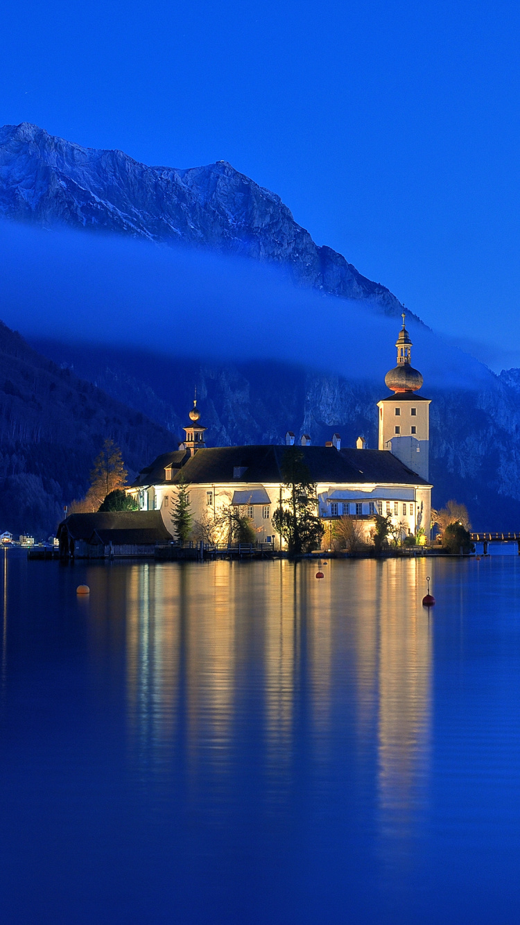 Bâtiment en Béton Blanc et Brun Sur le Quai Près de la Montagne Pendant la Journée. Wallpaper in 750x1334 Resolution