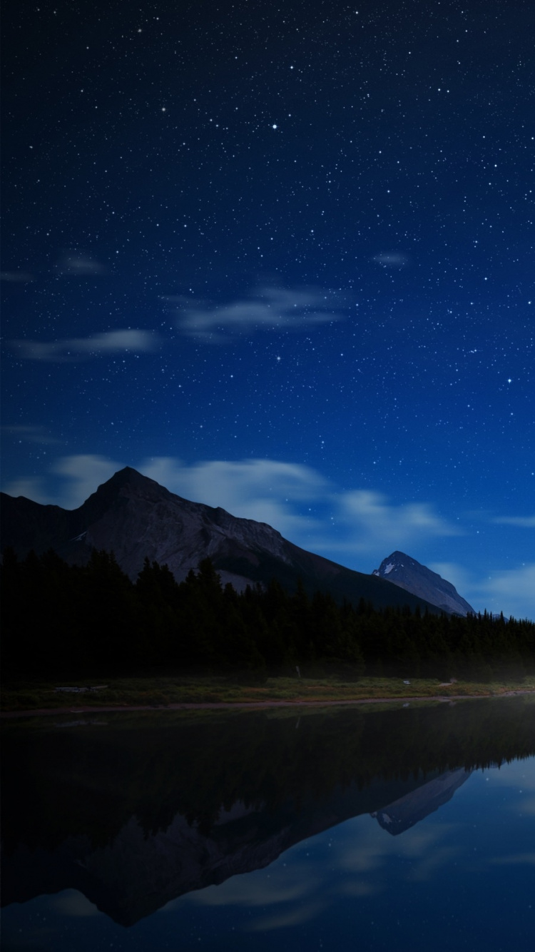 Gewässer in Der Nähe Des Berges Unter Blauem Himmel Während Der Nacht. Wallpaper in 750x1334 Resolution