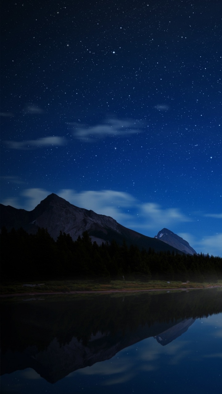 Cuerpo de Agua Cerca de la Montaña Bajo un Cielo Azul Durante la Noche. Wallpaper in 720x1280 Resolution