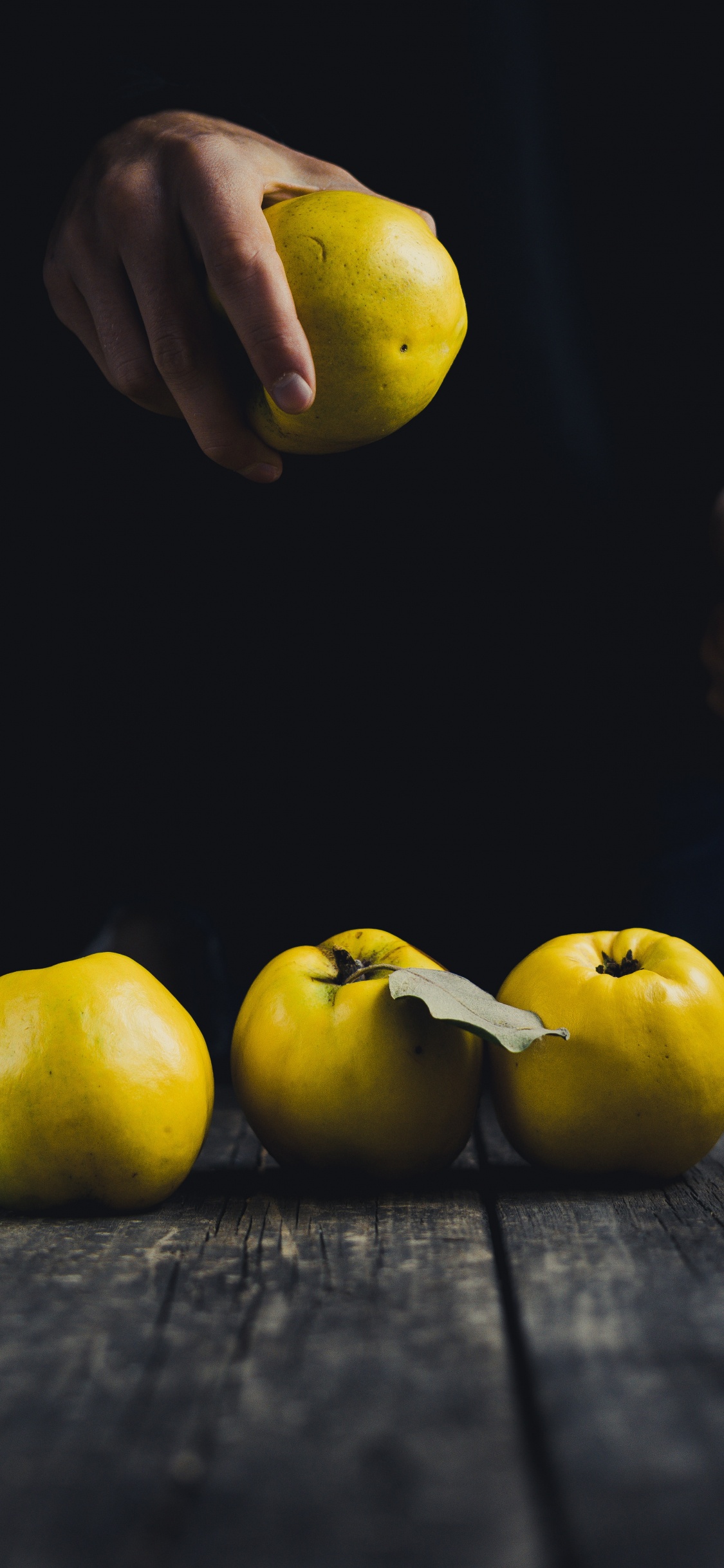 Manzana Amarilla Sobre Mesa de Madera Negra. Wallpaper in 1125x2436 Resolution