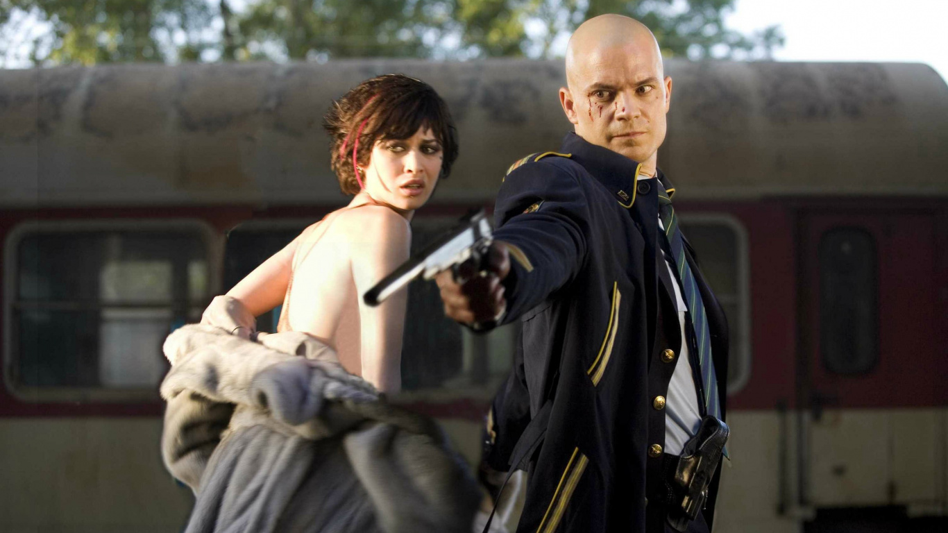 Homme en Manteau Noir Tenant un Fusil Noir. Wallpaper in 1366x768 Resolution