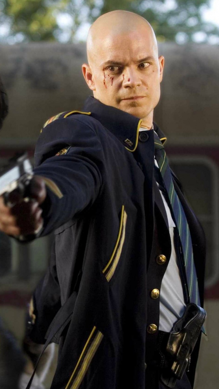 Man in Black Coat Holding Black Rifle. Wallpaper in 720x1280 Resolution