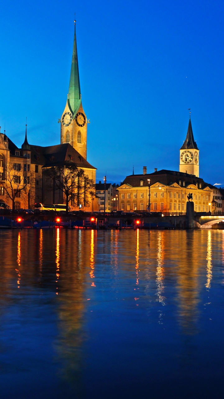 Braunes Und Grünes Betongebäude in Der Nähe Eines Gewässers Während Der Nacht. Wallpaper in 720x1280 Resolution