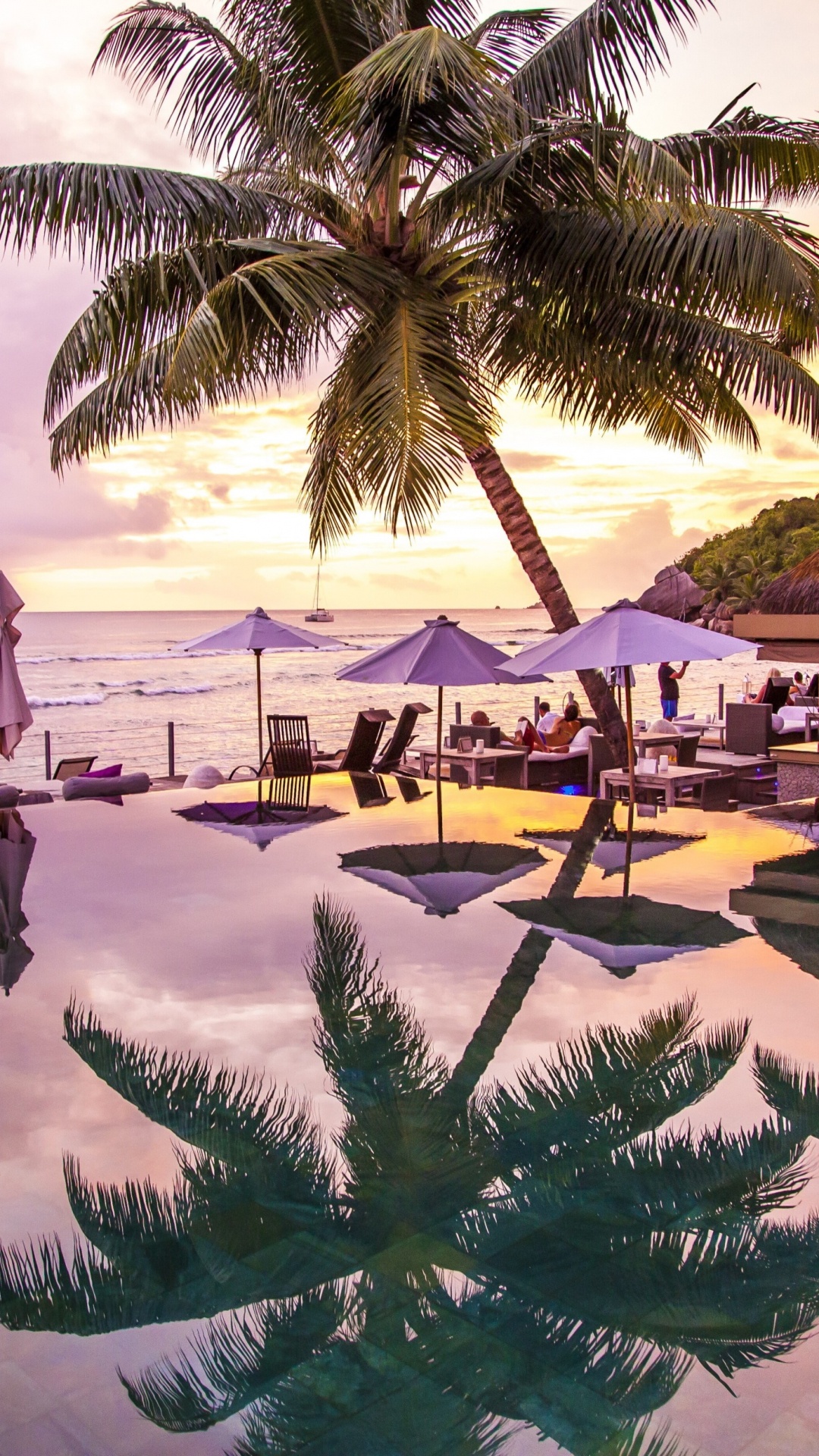 Hombre Con Camisa Negra y Pantalón Gris Caminando Por la Playa Durante el Día. Wallpaper in 1080x1920 Resolution