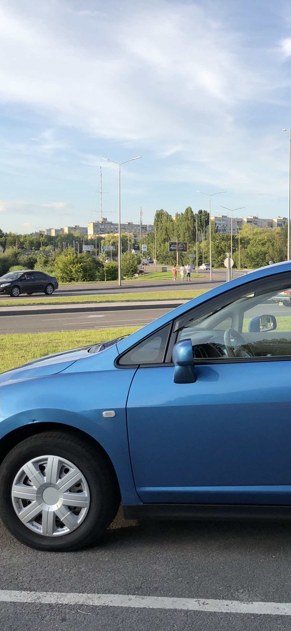 Suv Bleu Sur Route Asphaltée Grise Pendant la Journée. Wallpaper in 1125x2436 Resolution