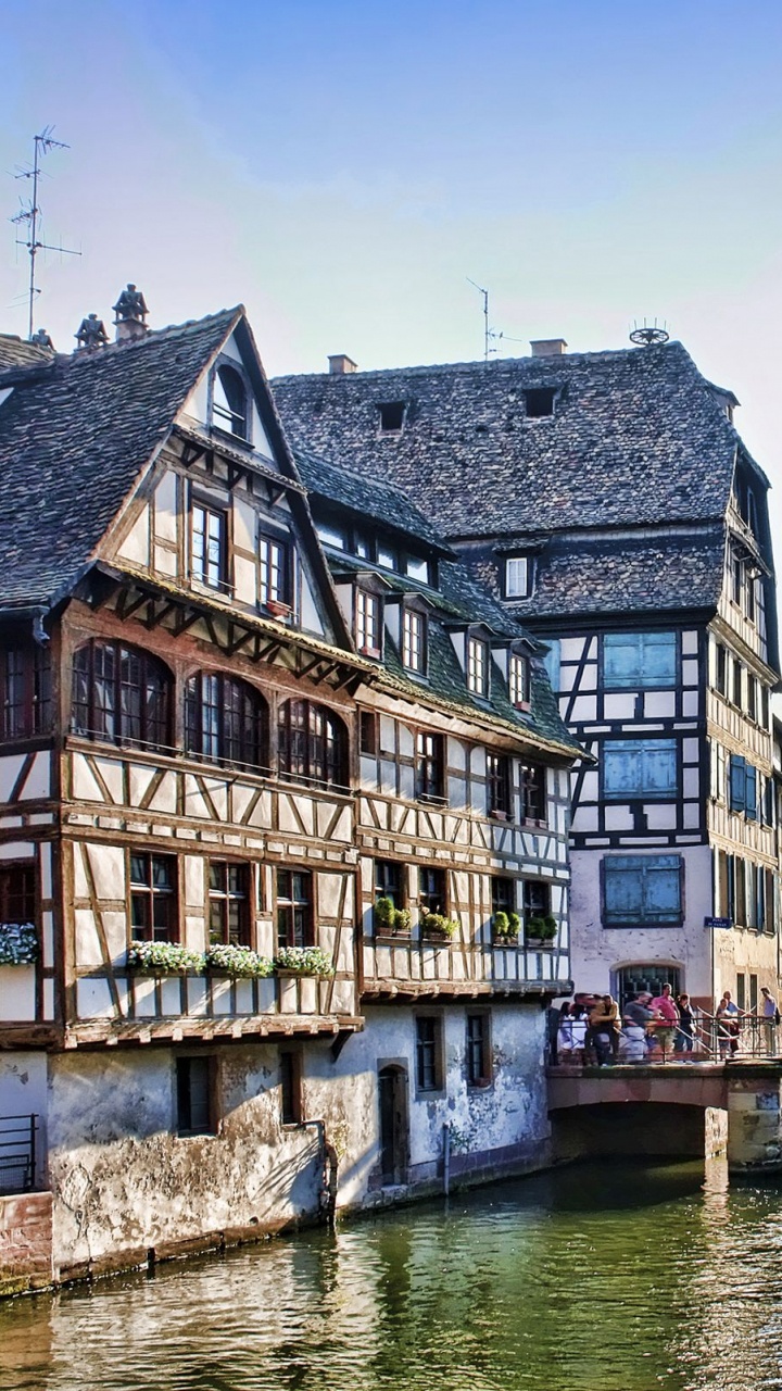 Bâtiment en Béton Brun et Blanc à Côté de la Rivière Pendant la Journée. Wallpaper in 720x1280 Resolution