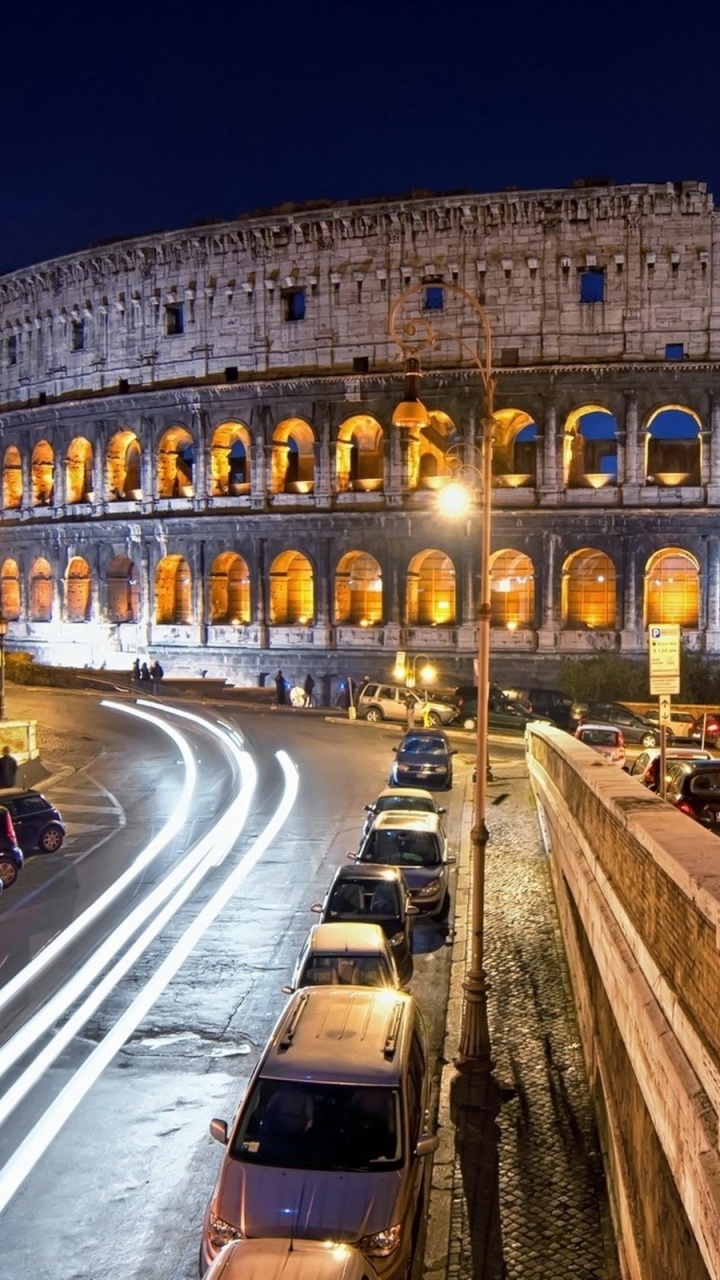 Coches en la Carretera Cerca Del Edificio de Hormigón Marrón Durante la Noche. Wallpaper in 720x1280 Resolution